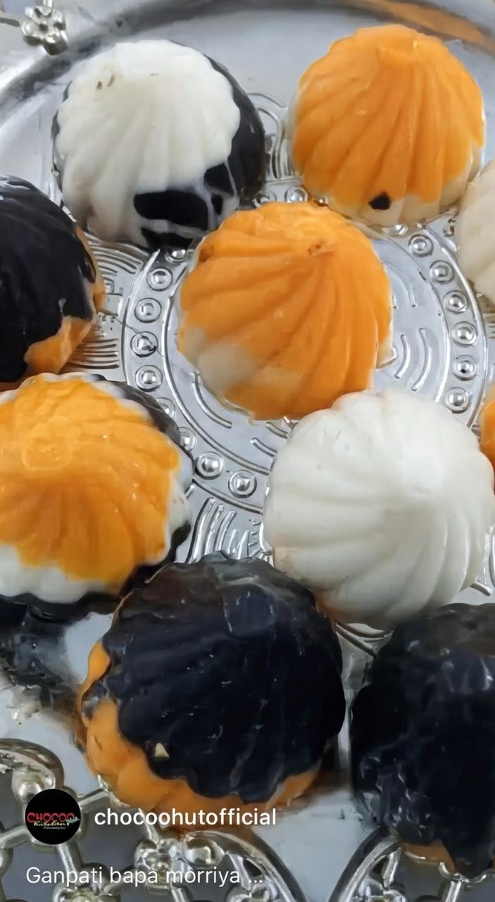 Assorted flavour handmade chocolate modaks on a silver plate for Ganesh Chaturthi